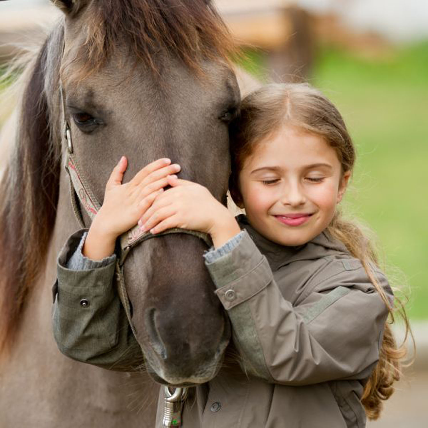 Una niña abrazando un pony
